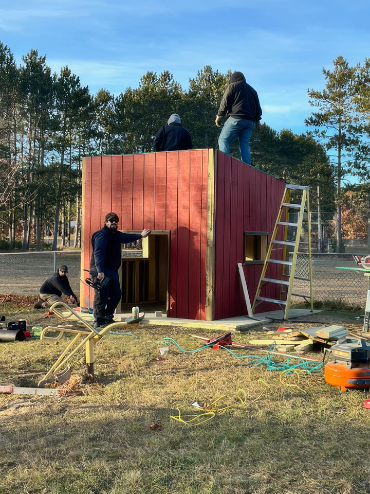 Domtar team members align materials to ensure the playhouse is built safely and precisely for the children who will use it.