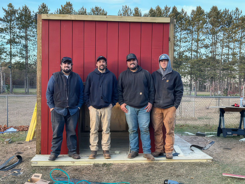 Volunteers from Domtar’s Nekoosa Mill stand with the new playhouse they built for pre-schoolers.